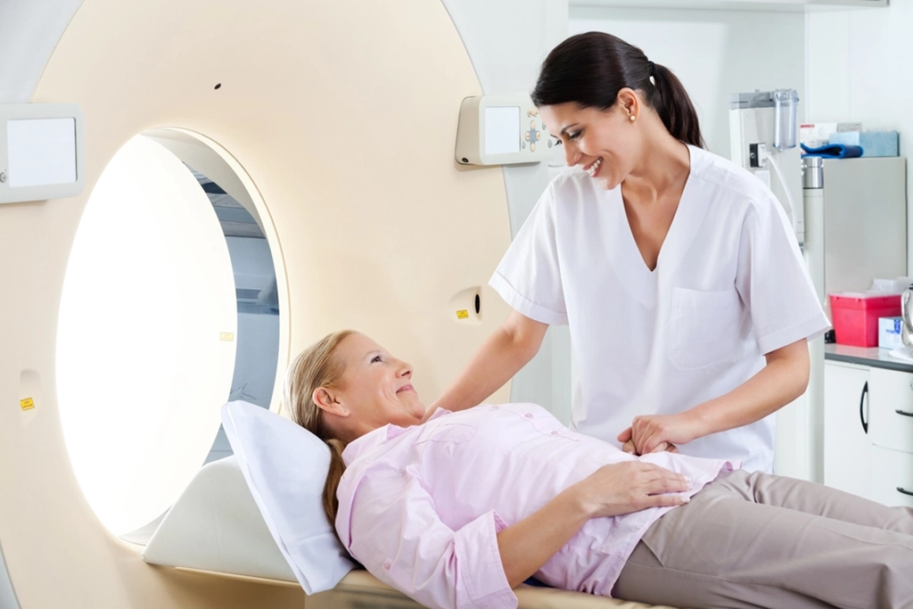 Female Technologist Smiling At Female Patient Before A CT Scan