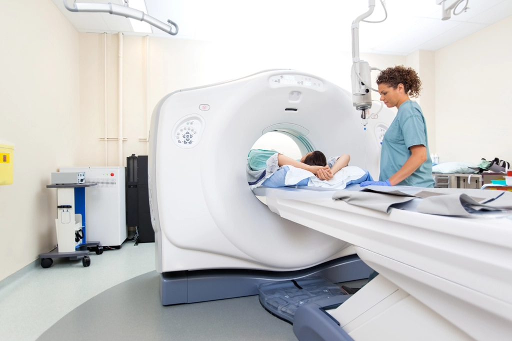 Female Technologist Operating A CT Scan Machine For A Male Patient