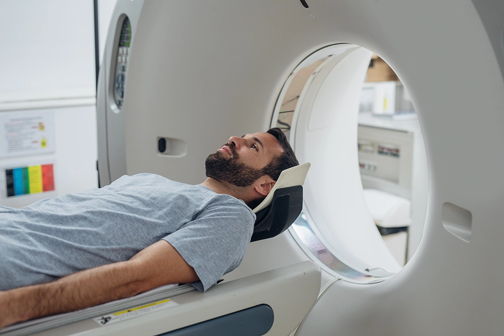 Patient Smiling As He Undergoes A CT Scan In A Comfortable Room